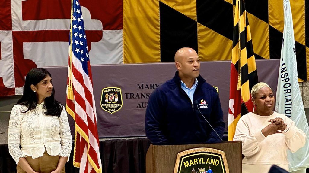 Maryland Governor Wes Moore gives updates on the collapse of the Francis Scott Key Bridge in Baltimore on April 1 and efforts to recover from the disaster with Lt. Gov. Aruna Miller (left) and April Jackson-Woodard, a freelance sign language interpreter, at his side.