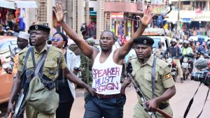 Policemen arrest a man as Ugandans began a March to Parliament anti-graft protest in Kampala on July 23, 2024.