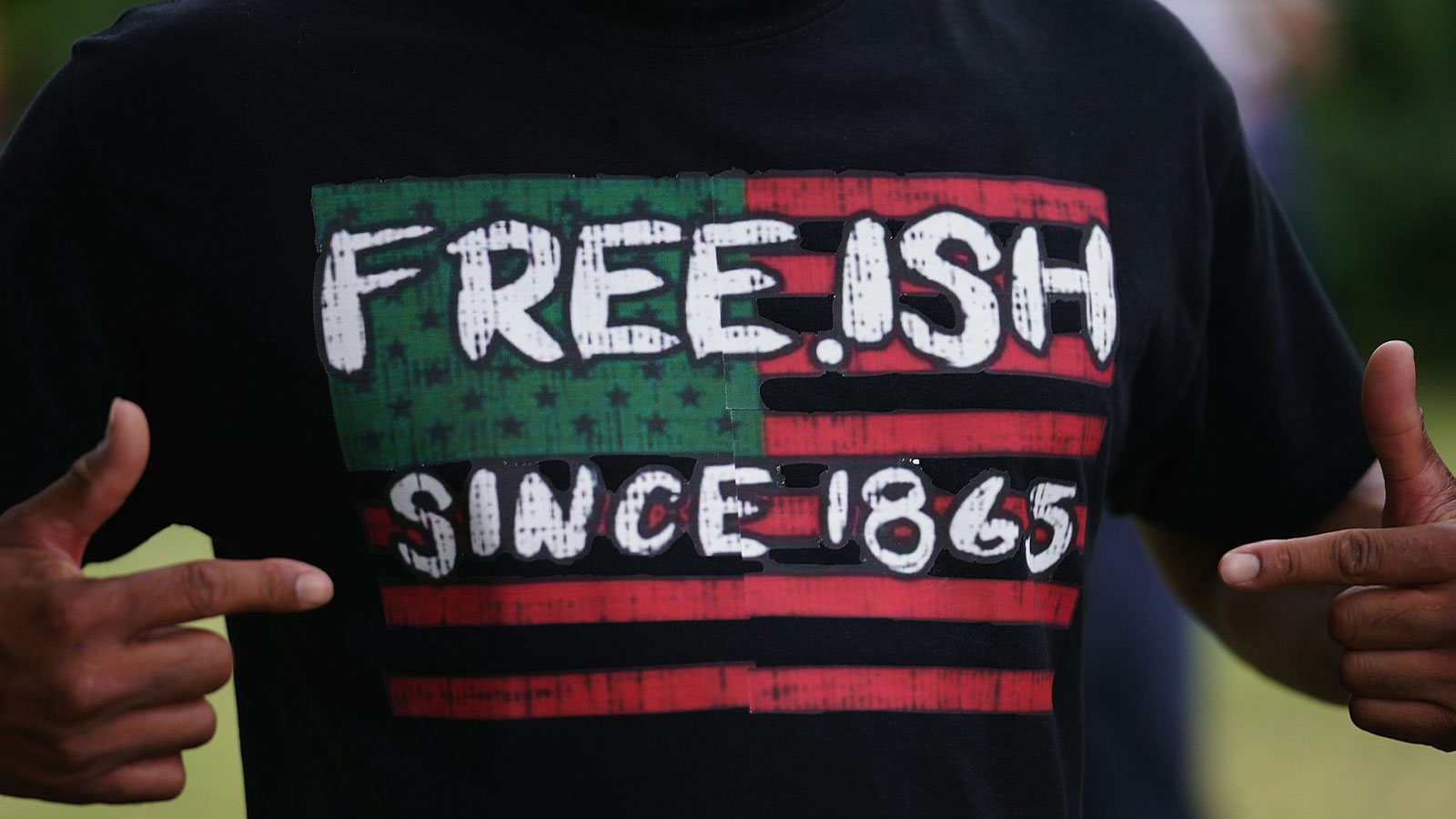 A man displays a shirt celebrating the freedom of enslaved Black people during a Juneteenth celebration in Tulsa, Okla.