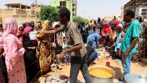 A volunteer distributes food to people in Omdurman, Sudan, September 3, 2023.