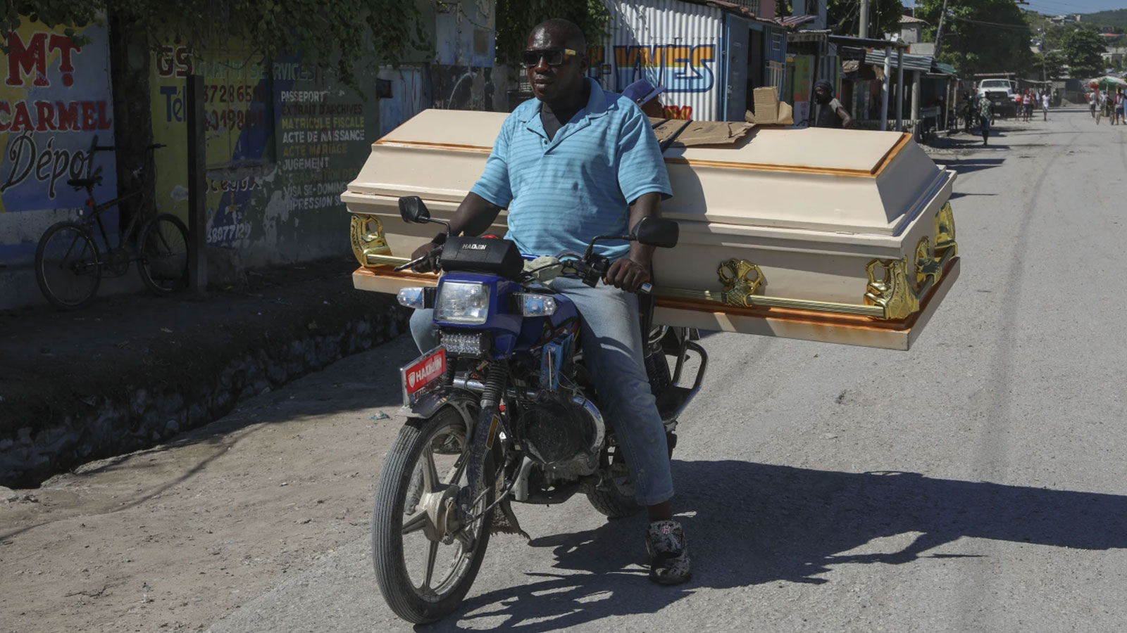 A motorist carries an empty coffin to a morgue for the funeral of a person killed the previous week when a gang attacked the town of Pont-Sonde, Haiti, Monday, Oct. 7, 2024.