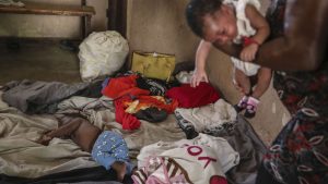 People displaced by armed gang attacks rest at the Antoinette Dessalines National School, a makeshift shelter, in Saint-Marc, Haiti, Sunday, Oct. 6, 2024.