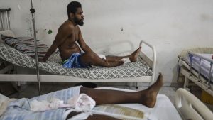 Exiles Junior, wounded by a bullet during armed gang attacks, sits up on a bed at Saint Nicolas hospital in Saint-Marc, Haiti, Sunday, Oct. 6, 2024.