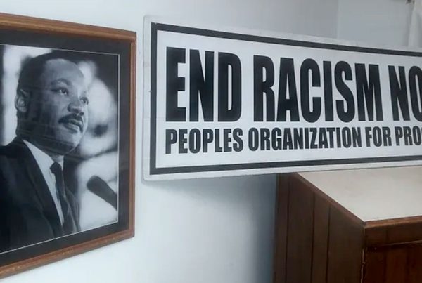 Framed photo of Martin Luther King Jr an an "End Racism Now" sign from Peoples Organization for Progress (POP).