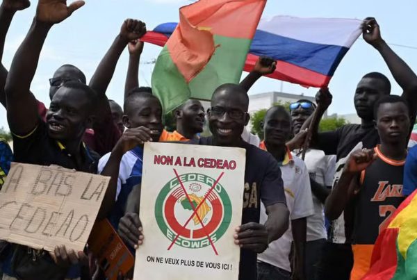 A small group of protesters hold Russian and Burkina Faso flags as they protest against ECOWAS in Ouagadougou in October 2022,