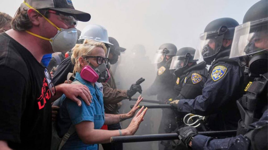 Protesters confront police on the 101 Freeway near the Metropolitan Detention Center of downtown Los Angeles, Sunday, June 8, 2025, following last night’s immigration raid protest.