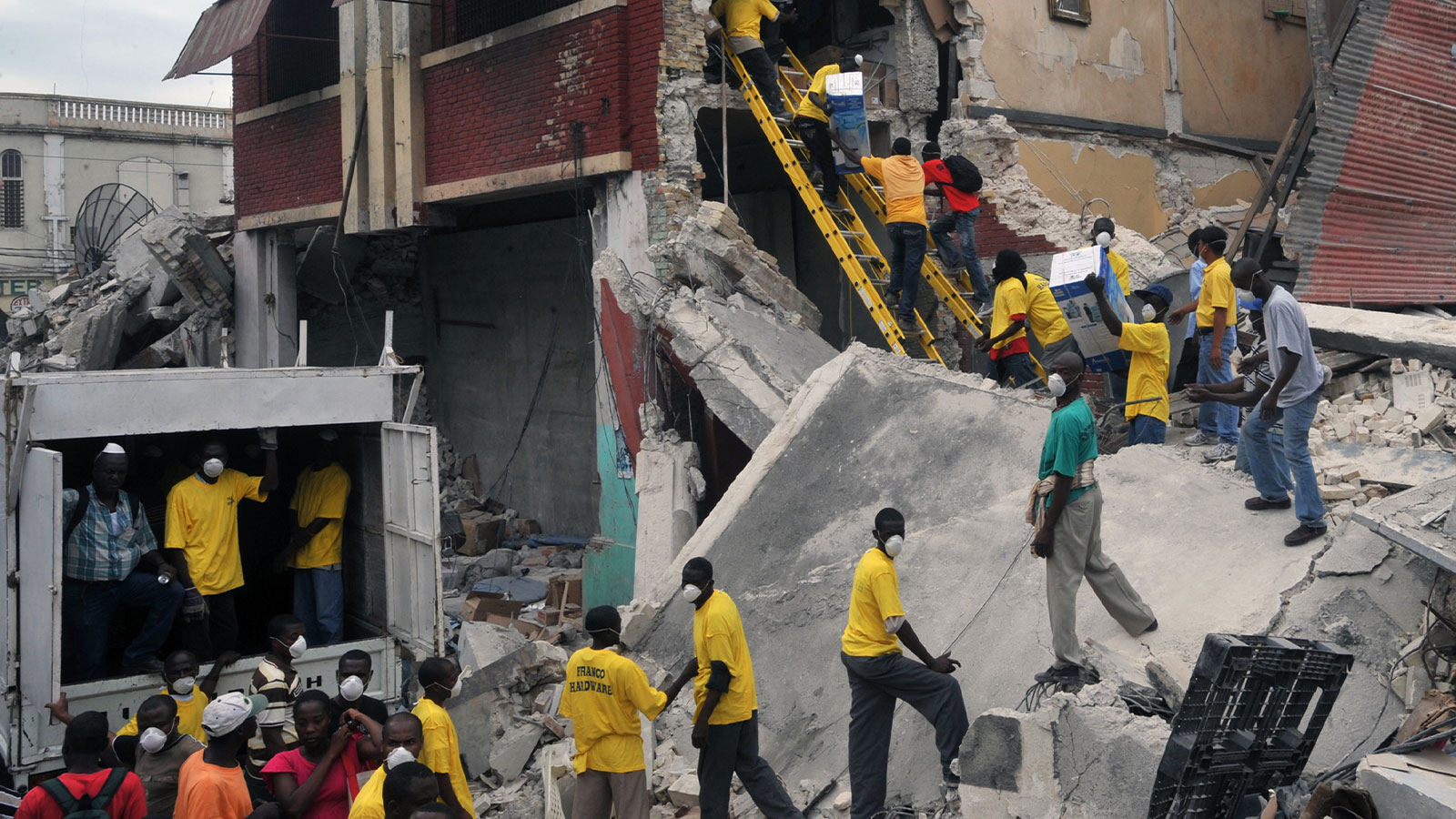 People walk through earthquake-damaged buildings in the Bel Air neighborhood of Port-au-Prince following Haiti's devastating 2010 earthquake. Photo: Marcello Casal Jr./ABr (Wikimedia Commons).